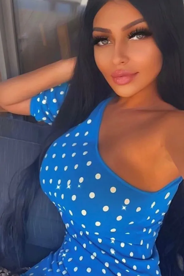 Melya wearing a blue polka dot dress. 